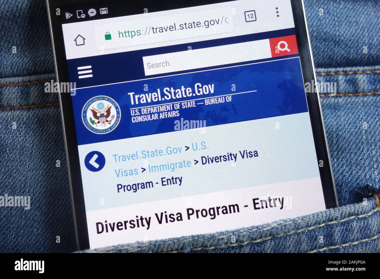 Website des US-Außenministeriums zum Diversity Visa-Programm wird auf dem Smartphone in der Jeans-Tasche versteckt angezeigt Stockfoto
