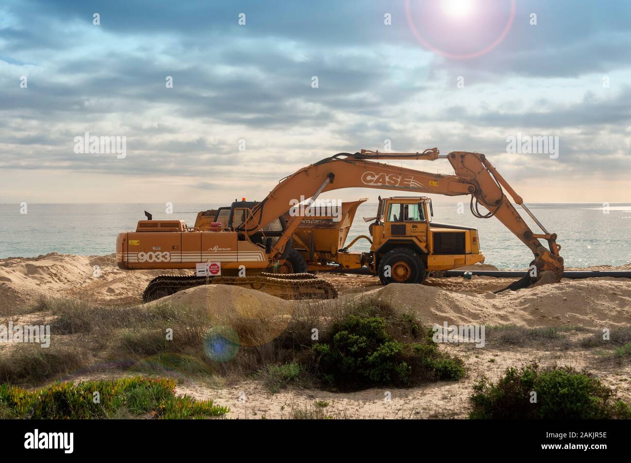 Bagger und Lkw an einem Strand, Sand den Strand infolge Küstenerosion zu reparieren. Stockfoto