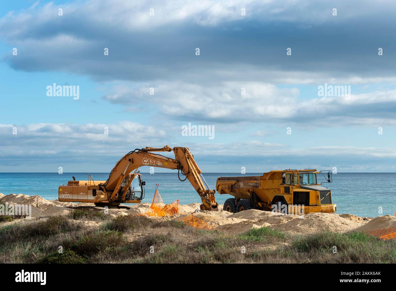 Bagger und Lkw an einem Strand, Sand den Strand infolge Küstenerosion zu reparieren. Stockfoto