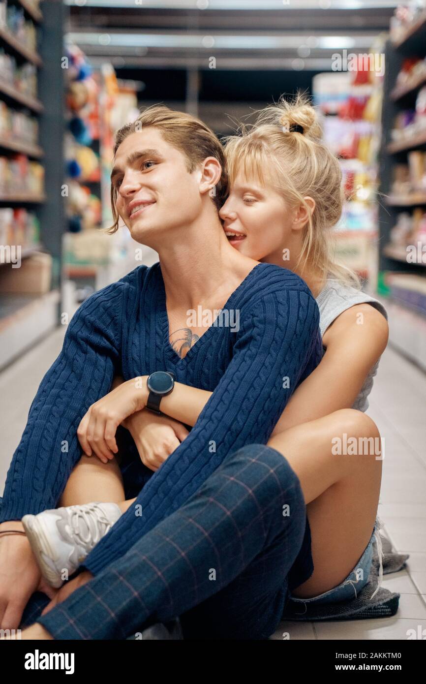 Junge Erwachsene Freund und Freundin umarmen im Supermarkt Stockfoto