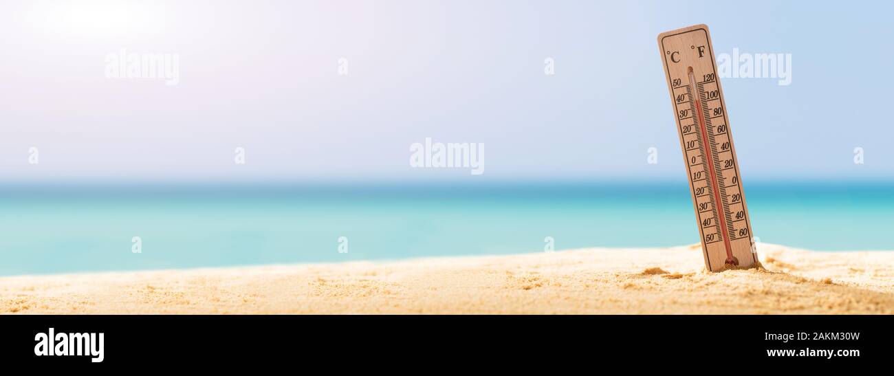 Thermometer auf Sandstrand mit hoher Temperatur Stockfoto