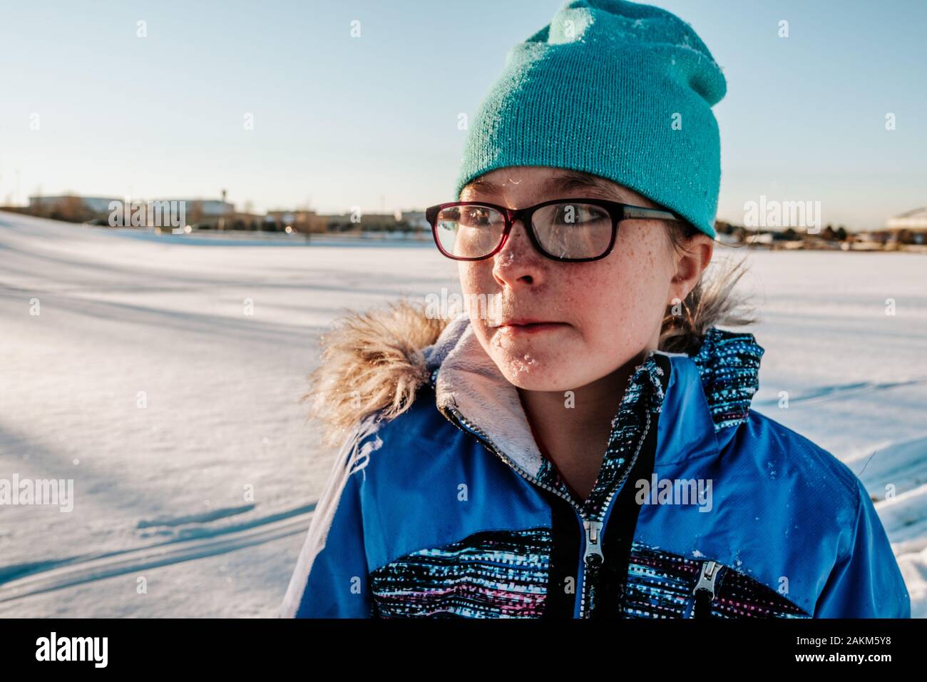 Porträt eines Mädchens mit Brille mit Schnee auf ihrem Gesicht im Winter Stockfoto