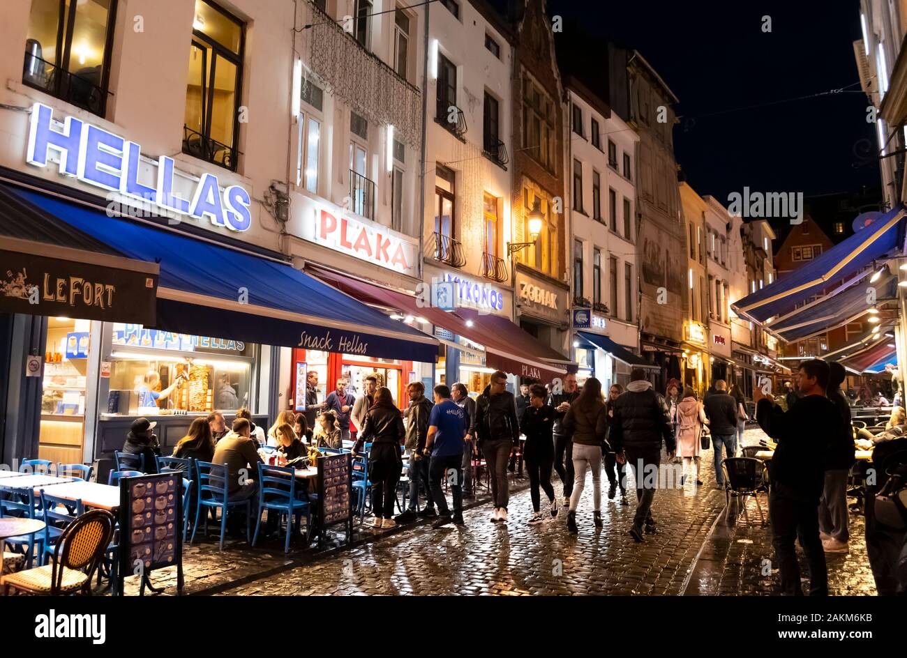 Griechische cafes säumen die Straße, in der historischen Altstadt von Brüssel Belgien an einem regnerischen bis spät in die Nacht in der geschäftige, überfüllte Stadt. Stockfoto
