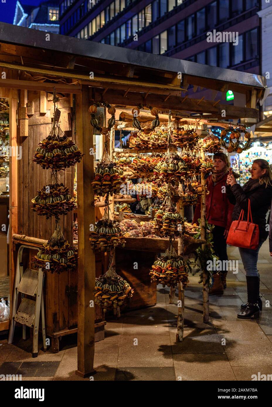 Zwei Frauen in einem Stall verkaufen Kunsthandwerk an der Weihnachts- und Adventsmarkt am Vörösmarty Platz in Budapest, Ungarn Stockfoto