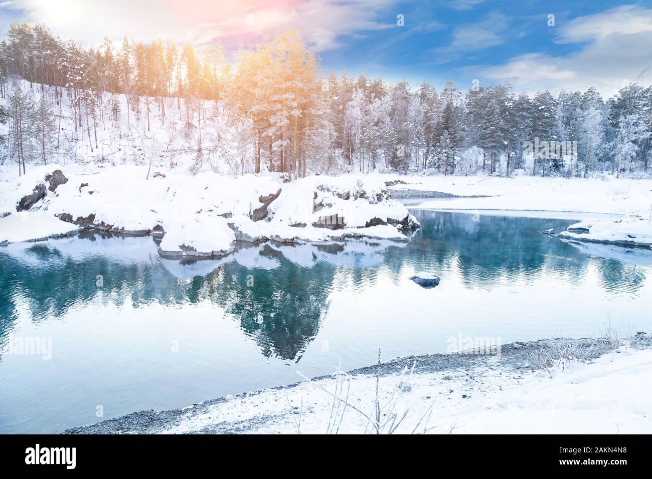 Sehenswürdigkeiten in den Bergen des Altai, blaue Seen nicht Einfrieren im Winter um Steine mit grünem Schlamm bedeckt mit Schnee, in denen Bäume und Himmel sind refle Stockfoto