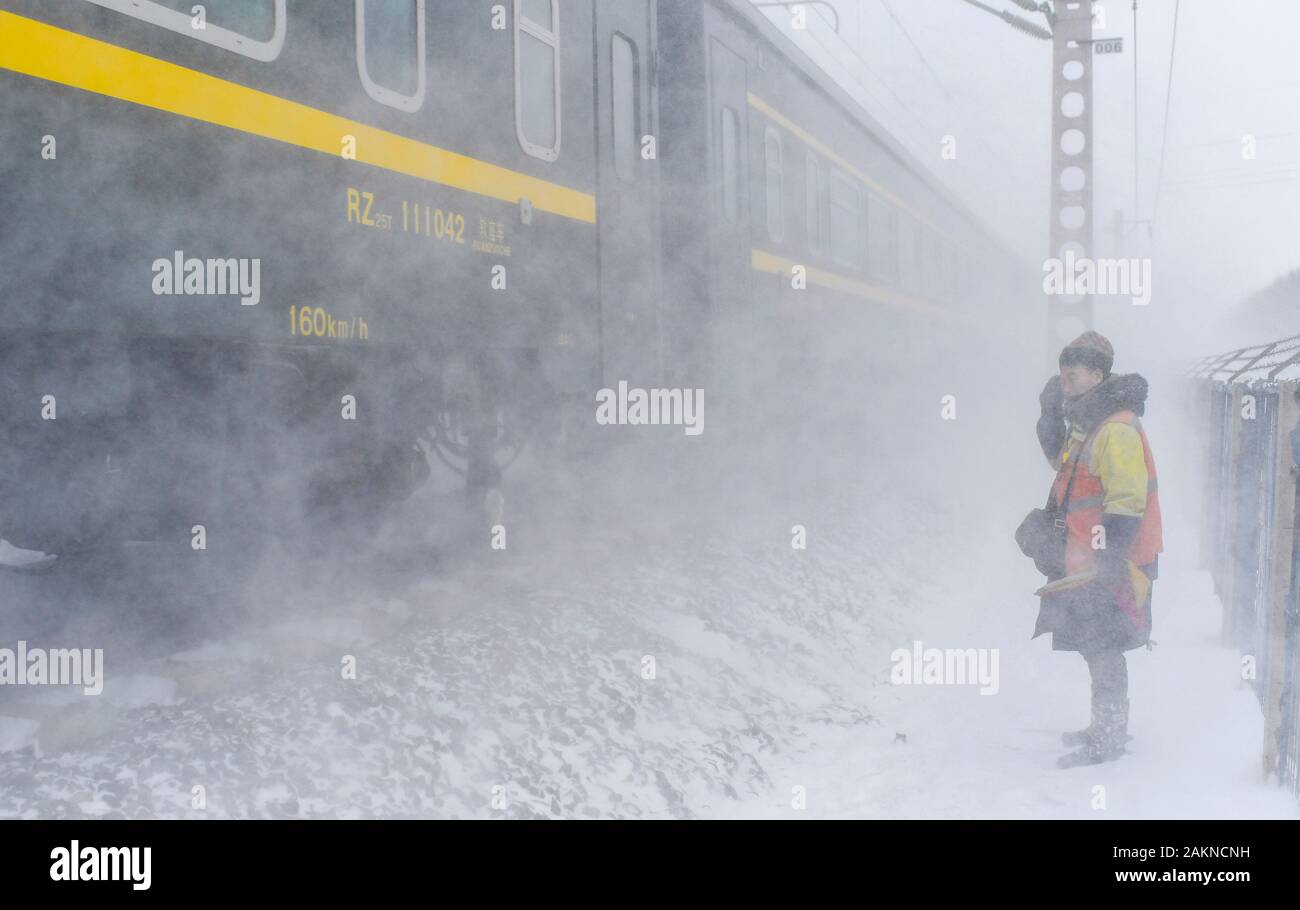 Peking, China. 8 Jan, 2020. Eine Uhr - Halter eines rail Fehlererkennung Team steht Wache, wenn ein Zug vorbeifährt im Nordosten der chinesischen Provinz Jilin auf Jan. 8, 2020. Credit: Xu Chang/Xinhua/Alamy leben Nachrichten Stockfoto