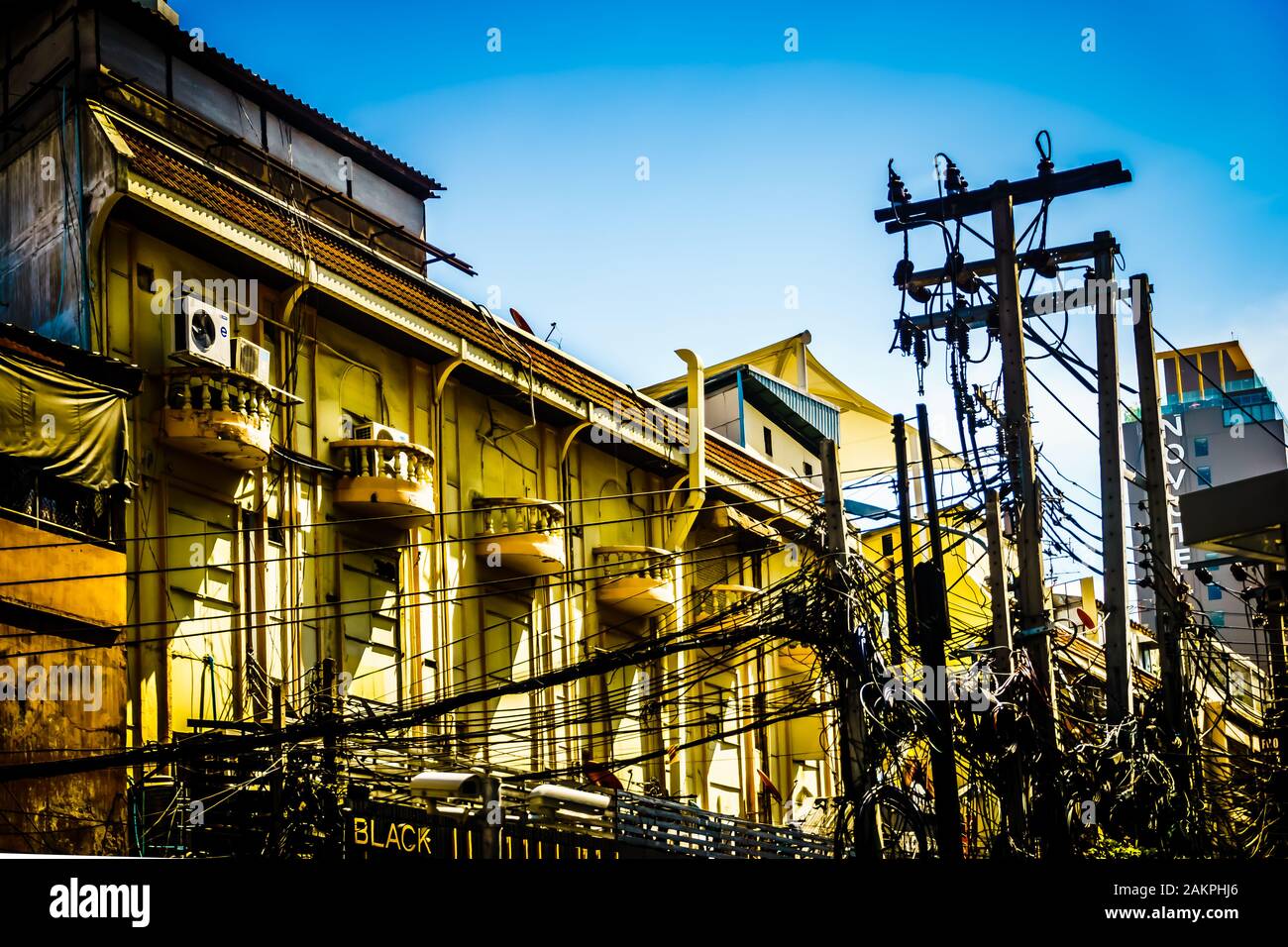 Das verwirrte und unordentliche Elektrokabel, die Telefonleitung hängt von einem Stromanschluss auf der Straße von Bangkok, die Bangkok mit Strom versorgt. Stockfoto