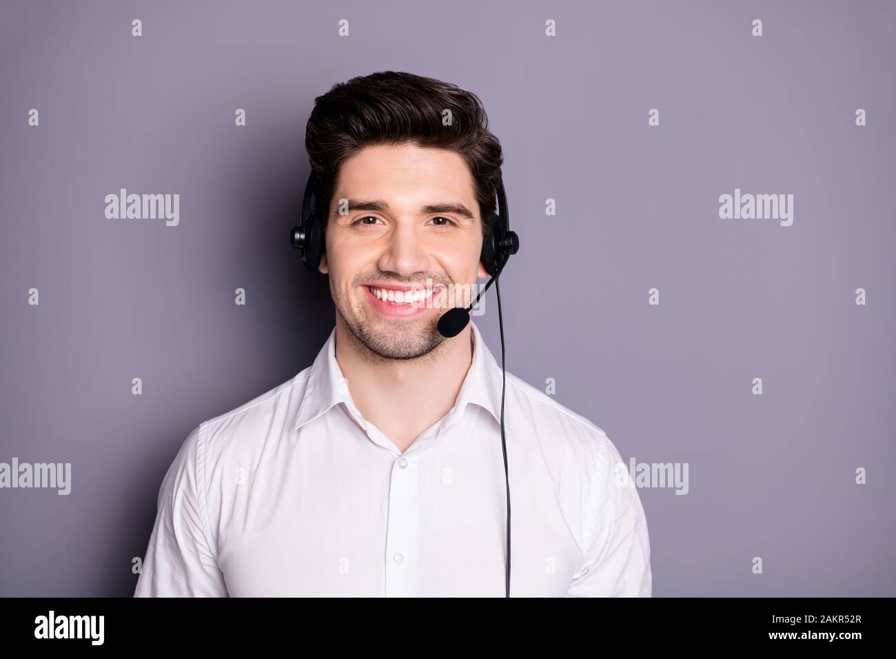 Portrait eines selbstbewussten, cool positiven Callcenter-Mitarbeiters kann bei Problemen helfen, schwarze Kopfhörer zu tragen, formalwear Kleidung isoliert über graue Farbe Stockfoto