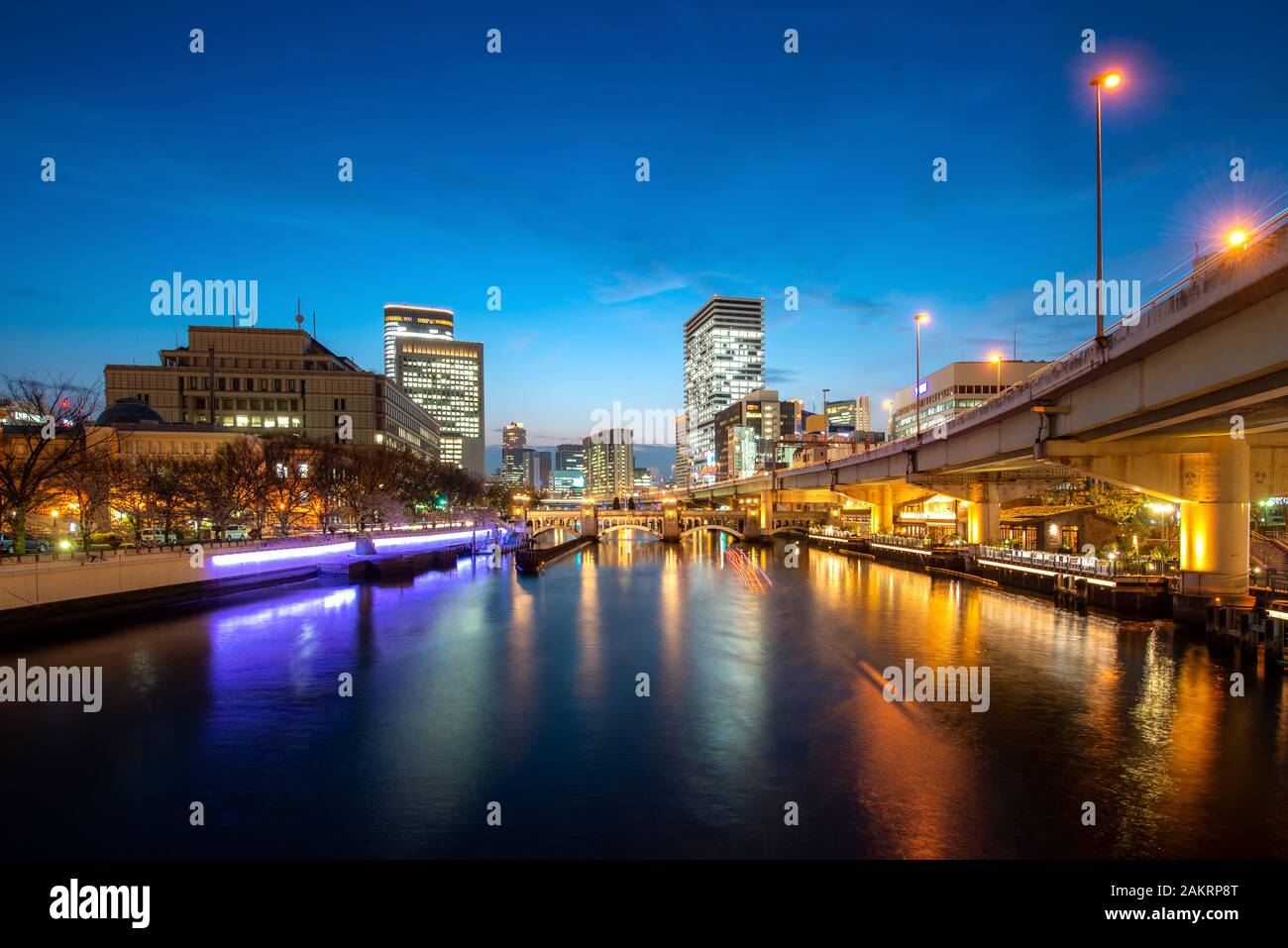 Osaka Hochhaus Gebäude mit Tosahori Fluss in Nakanoshima business district in der Nacht in Osaka, Japan. Japan Tourismus, moderne Stadt leben, oder Business Stockfoto