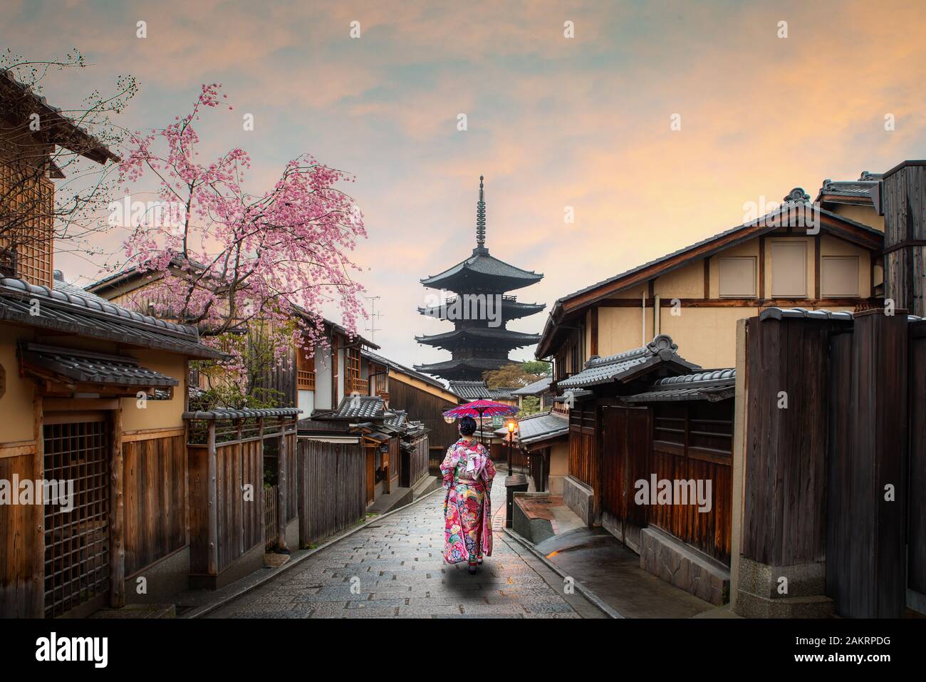 Asiatische junge Frau Reisenden tragen traditionelle japanische Kimono mit roten Regenschirm Sightseeing in berühmten Ziel Sannen Zaka Straße mit historischen Stockfoto