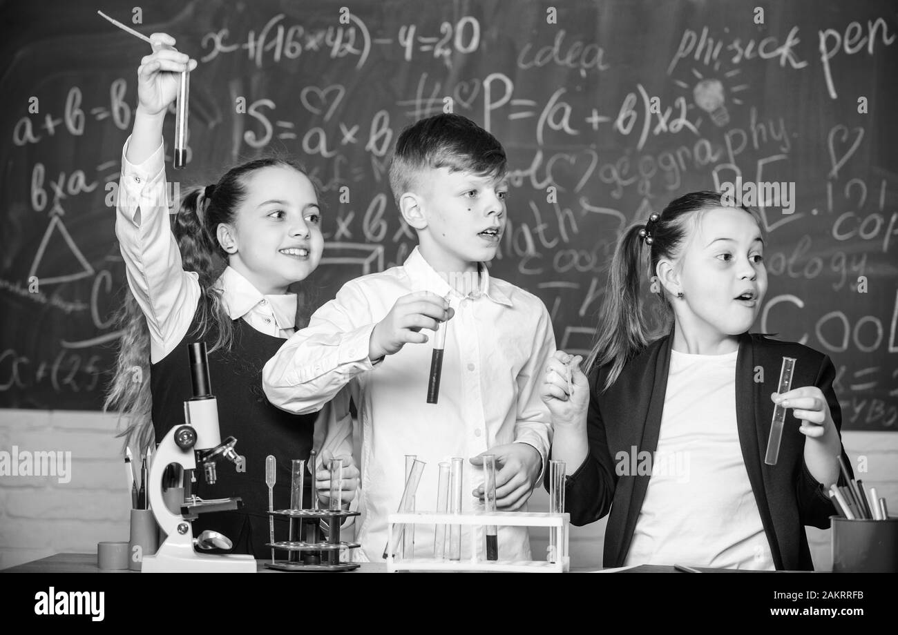 Chemische Ausrüstung. Chemische Ausbildung. Glückliche Kinder. Chemieunterricht: Studenten, die Biologieexperimente mit Mikroskop im Labor durchführen. Kleine Kinder lea Stockfoto
