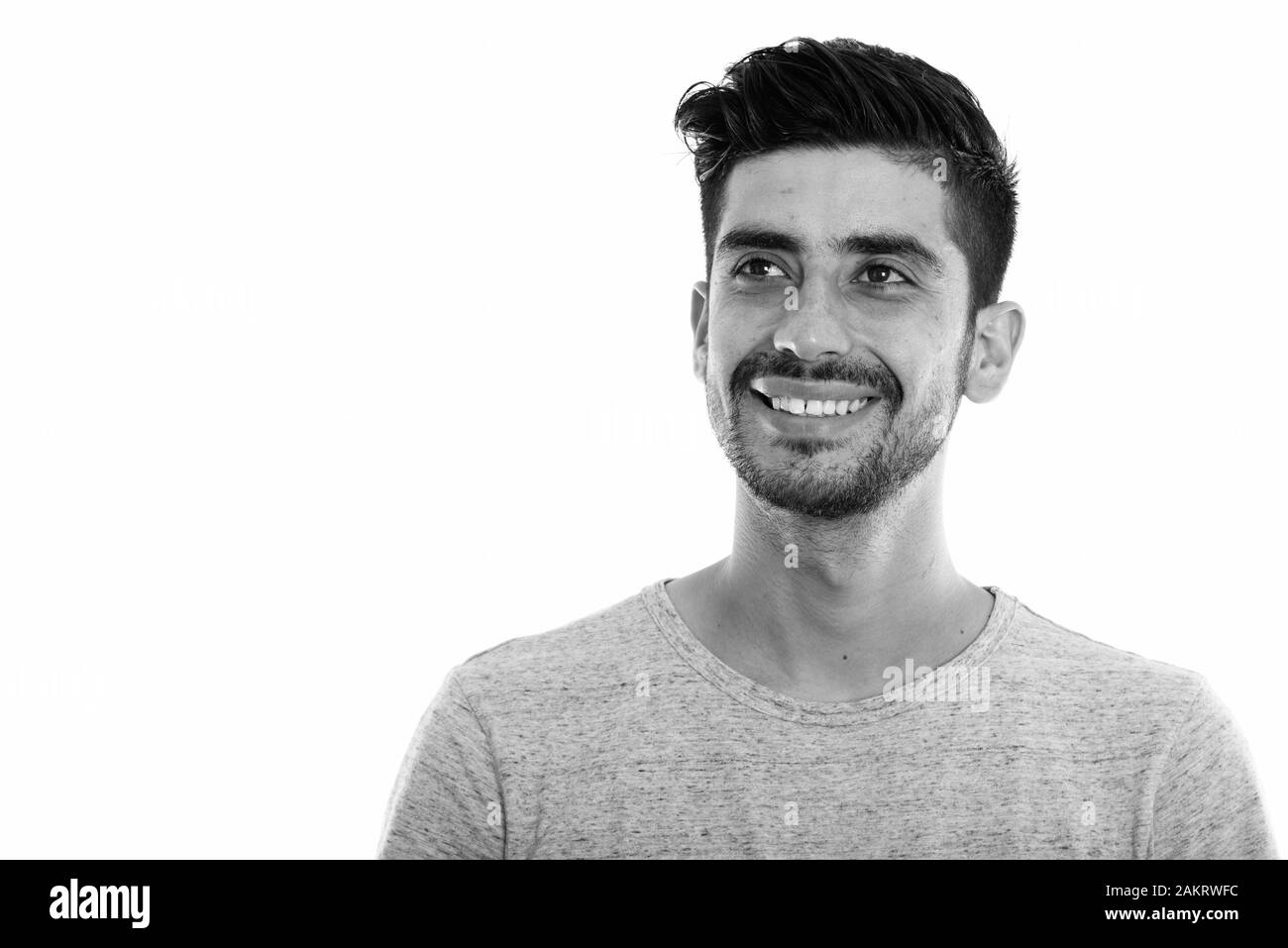 Studio shot der Jungen glücklich Persischen Mann lächelnd und denken beim Suchen Stockfoto