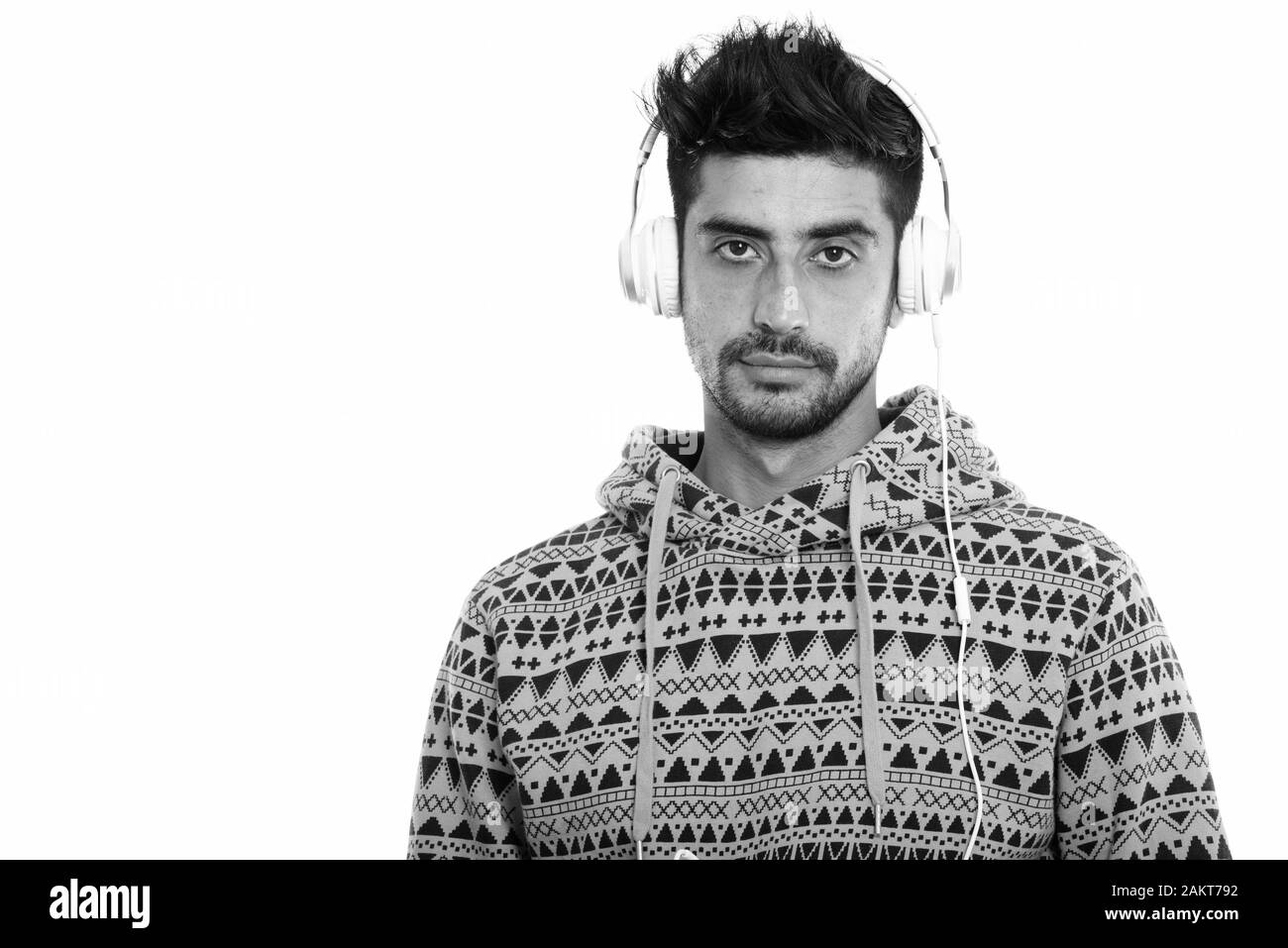 Studio shot der jungen Persischen mann Hören von Musik Stockfoto