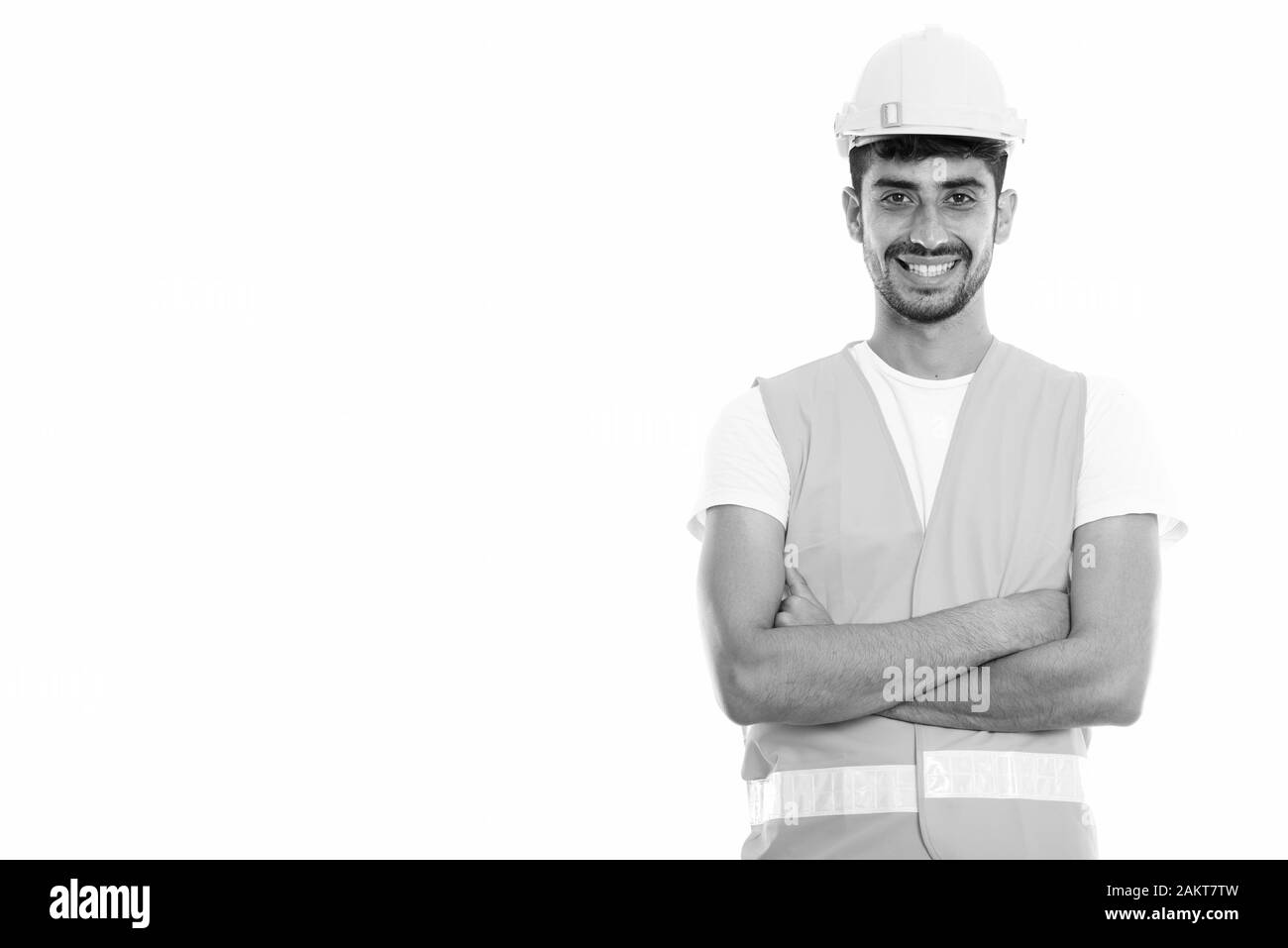 Studio shot der Jungen glücklich Persischen mann Bauarbeiter lächelnd mit gekreuzten Armen Stockfoto