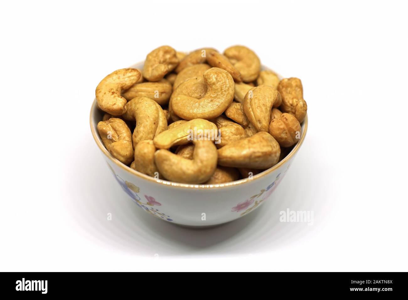 Geröstete Kaschew Nüsse zum Schnacken und Kochen, auf weißem Hintergrund geschlossen. Stockfoto
