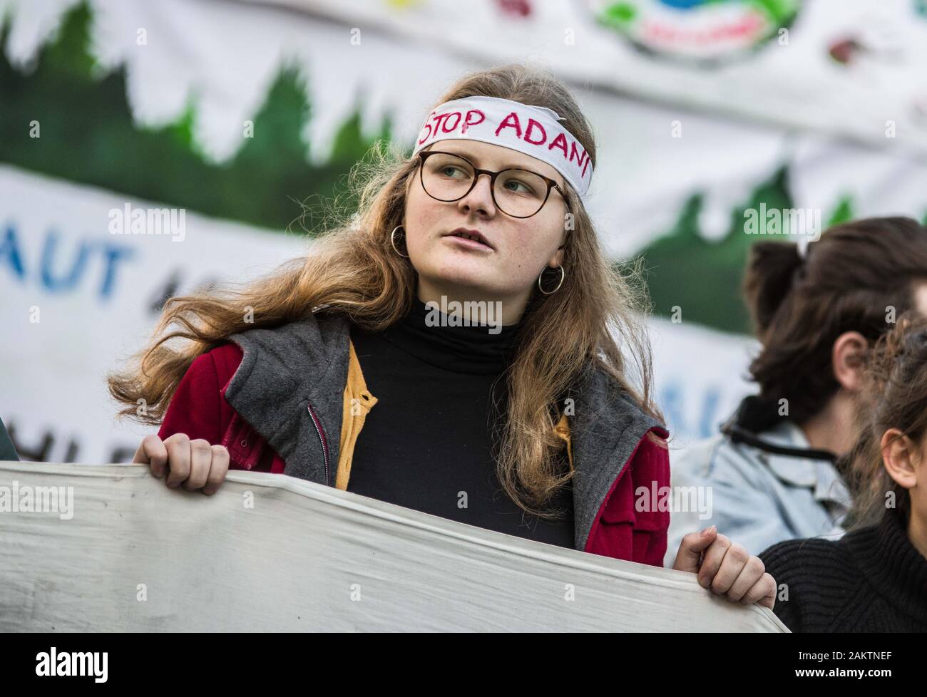 Januar 10, 2020: ein Jugendlicher demonstrant an der Siemens Hauptverwaltung in München, Deutschland, trägt ein ''Stop Adani'' Zeichen im Protest des Siemens-Adani mein Projekt in Australien. Läuft kontinuierlich mit den wöchentlichen Protesten, Freitags für zukünftige Teilnehmer, ein stiller Protest Aktion an der Siemens Hauptverwaltung in München durchgeführt. Siemens hat vor kurzem unter Feuer für seine Partnerschaft mit dem adani Carmichael Coal Mine Projekt in Australien kommen. Während einige 61 Unternehmen zurückgewiesen haben, arbeiten mit Adani, Siemens hat die Arbeit der Mine switching Systeme zu bauen fort, doch hat gesagt, daß es Mak Stockfoto