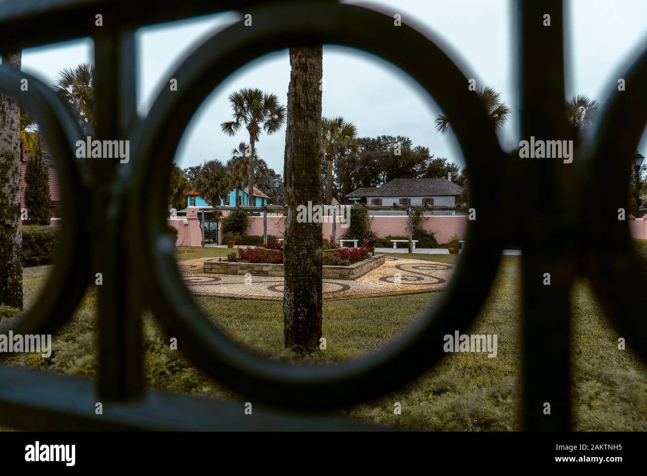Blick in einen Park durch einen eisernen Zaun im historischen St. Augustine in Florida, USA Stockfoto