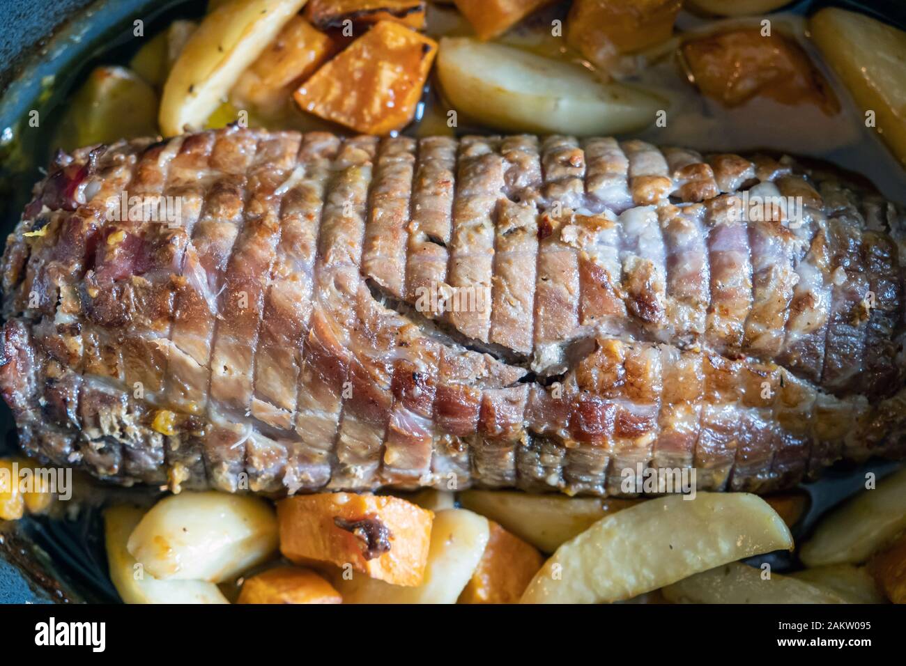 Gebratenes Schweinefleisch, Geflügel Roulade mit Kartoffeln auf einem Tablett serviert. Eine gesunde gefüllt als Mittagessen für Gourmets. Nahaufnahme, oben betrachten. Stockfoto