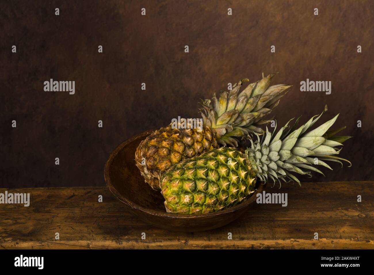 Dunkle noch Leben mit frischen Ananas auf einem antiken Holztisch Stockfoto
