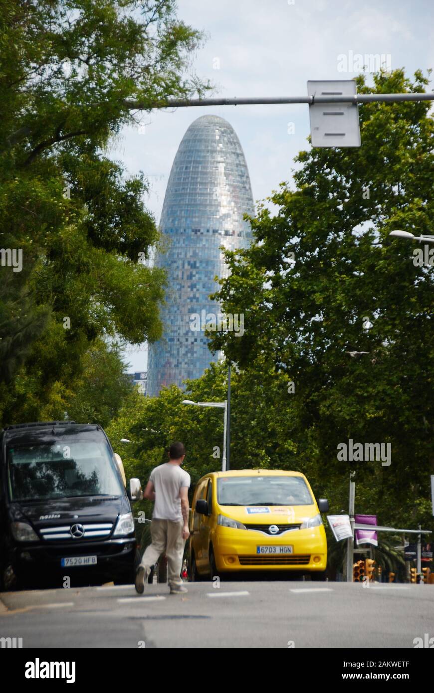 Barcelonas Agbar-Turm in der Ferne mit gelbem Lieferwagen im Vordergrund Stockfoto