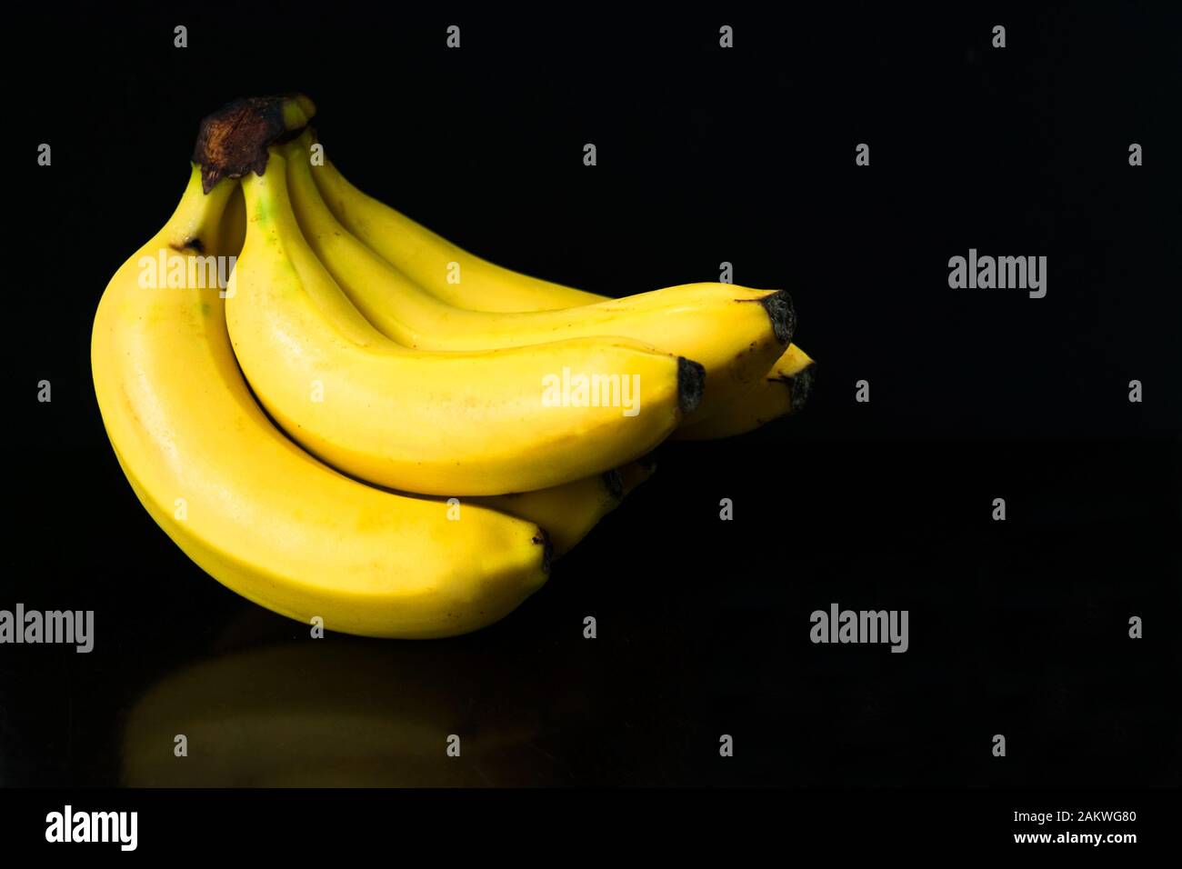 Ein Haufen Bananen isoliert auf schwarzem Hintergrund. Kopierbereich. Stockfoto
