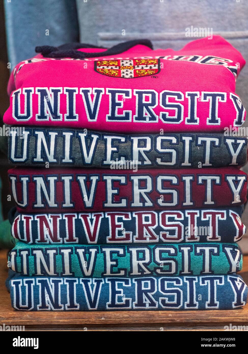 University Sweatshirts, University Hoodies, University Jumper, University Pullover. Haufen von Pullovern an der Universität Cambridge in einem Ausstatterfenster. Stockfoto