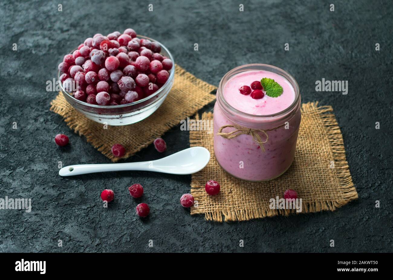 Gefrorener Preiselbeer-Joghurt auf schwarzem Hintergrund. Das Konzept gesunder Desserts. Stockfoto