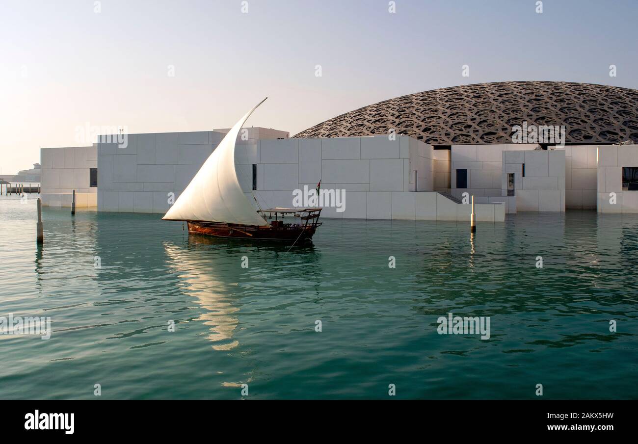 Abu Dhabi/VAE - Januar 3, 2019: Louvre in Abu Dhabi. Blick auf den wunderschönen Louvre außen mit Wasser und Holz Segelboot. Stockfoto