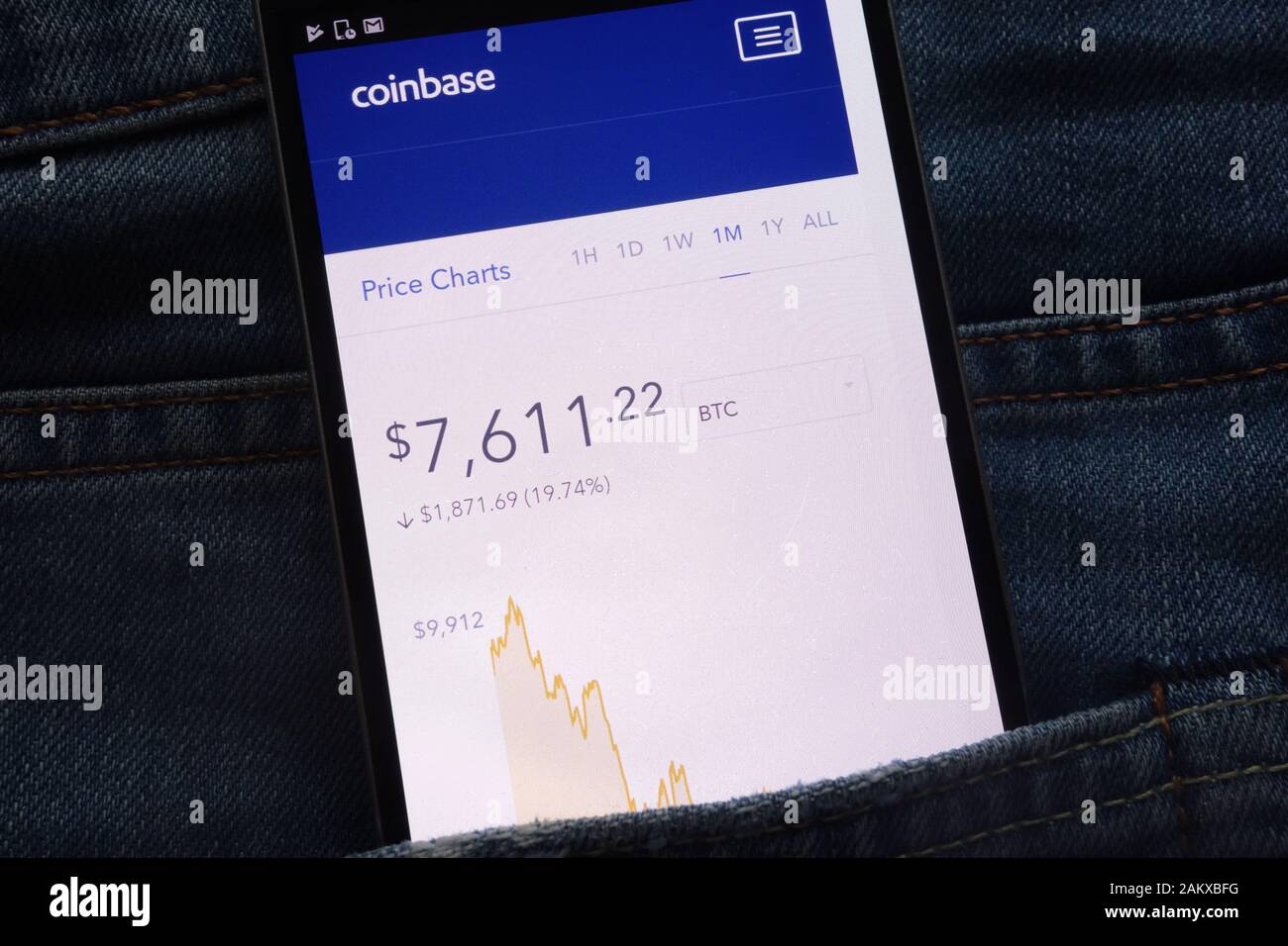 Coinbase Website mit Bitcoin-Preistabelle, die auf dem Smartphone in der Jeans-Tasche versteckt ist Stockfoto