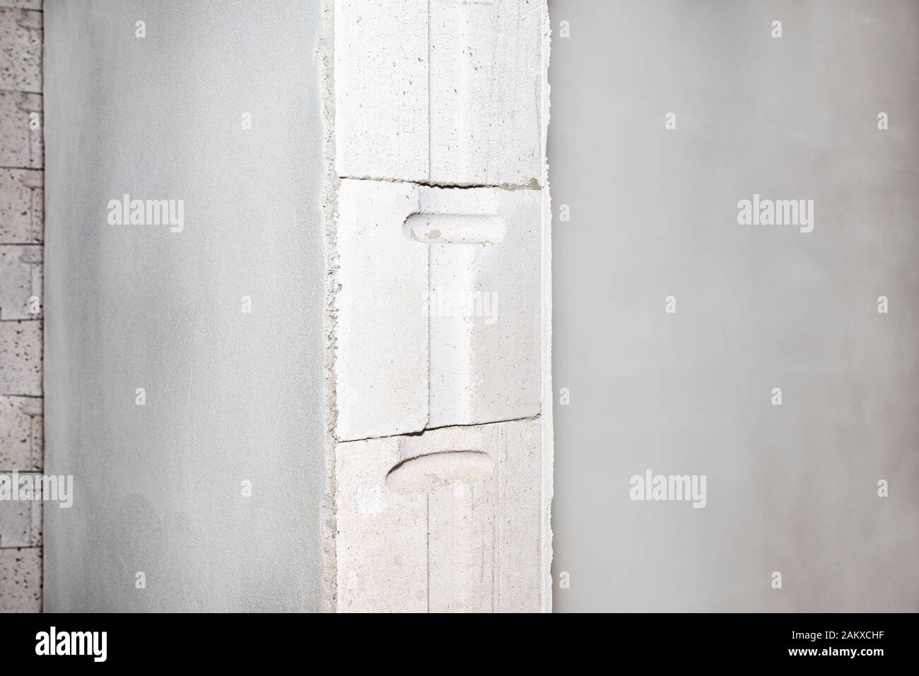Frisch verputzte Wände, sichtbar nicht verputzte Ziegel, die Einbettung der Türpfosten. Stockfoto