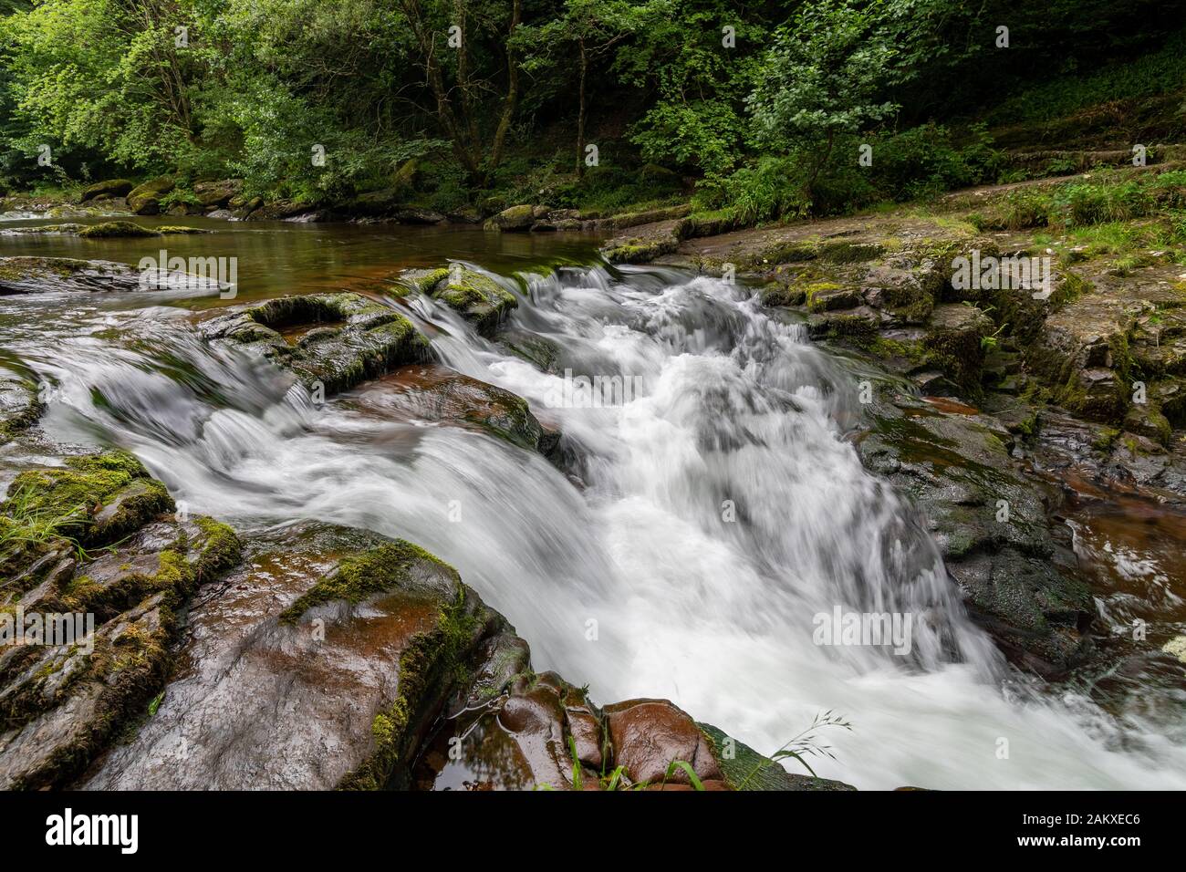 Lange Exposition des Wasserfalls am Watersmeet Bridge Pool in Watersmeet in Devon Stockfoto