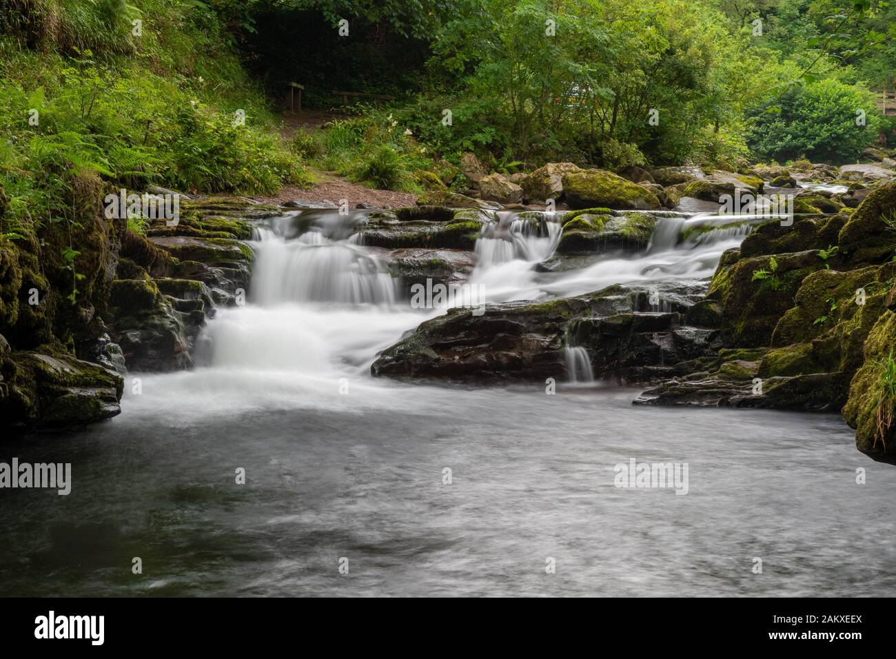 Lange Exposition des Wasserfalls am Watersmeet Bridge Pool in Watersmeet in Devon Stockfoto