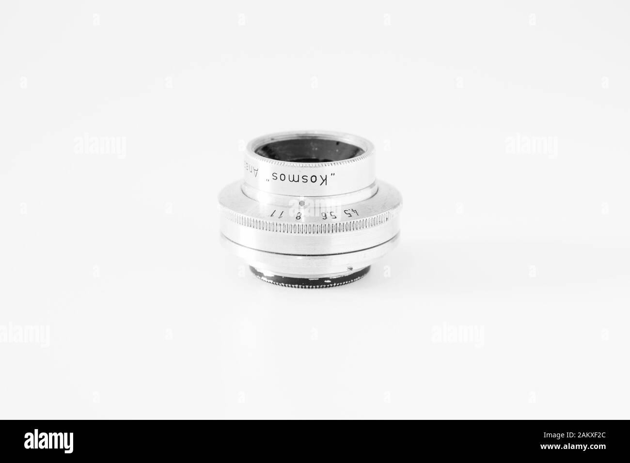 Altes Objektiv, 60 mm Marke "Kosmos", fotografiert auf weißem Hintergrund, in Schwarzweiß aufgenommen. Stockfoto