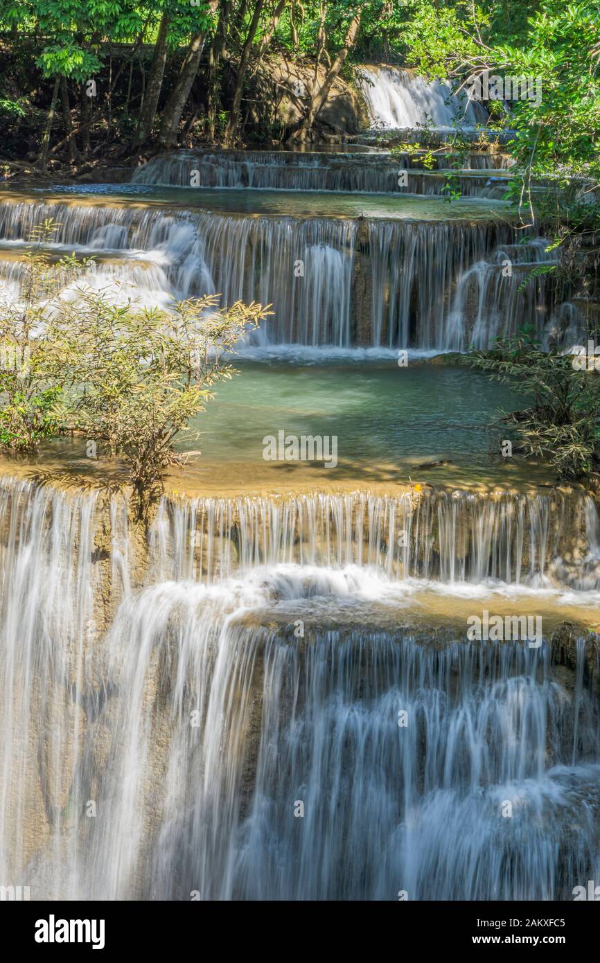 Das klare Wasser des Wasserfalls zirkuliert durch den gelben Kalkstein. Aussichtspunkt "Huai Mae Kamin Waterfall", Provinz Kanchanaburi Stockfoto