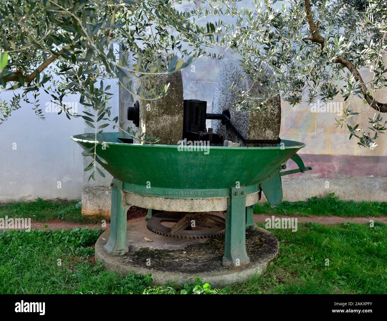 Alte traditionelle historische Oliven zerkleinern Maschine mit Stein Räder, die vor der Extraktion von Öl aus den Oliven verwendet worden wären Stockfoto