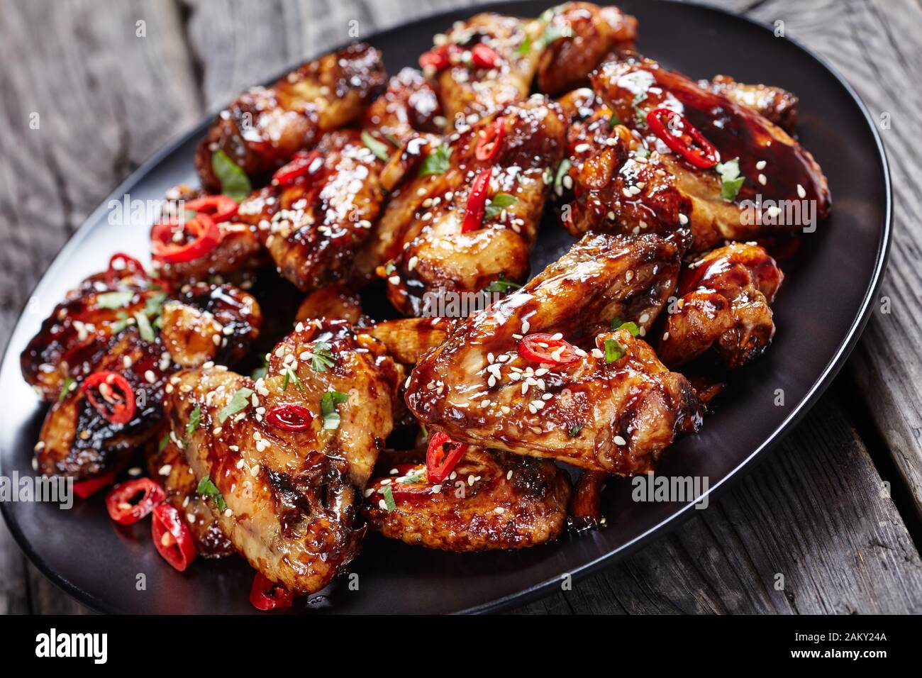 Oven Baked Teriyaki Chicken Wings Bestreut Mit Sesamsamen Chili Pfefferstucken Und Petersilie Auf Einem Schwarzen Teller Auf Einem Rustikalen Holztisch Blick Von A Stockfotografie Alamy