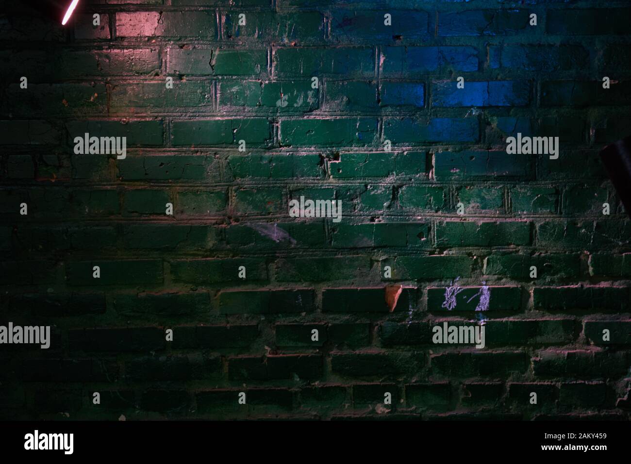 An der Wand aus grünem, blauem Faden und rosafarbenem Licht einer Laterne Stockfoto