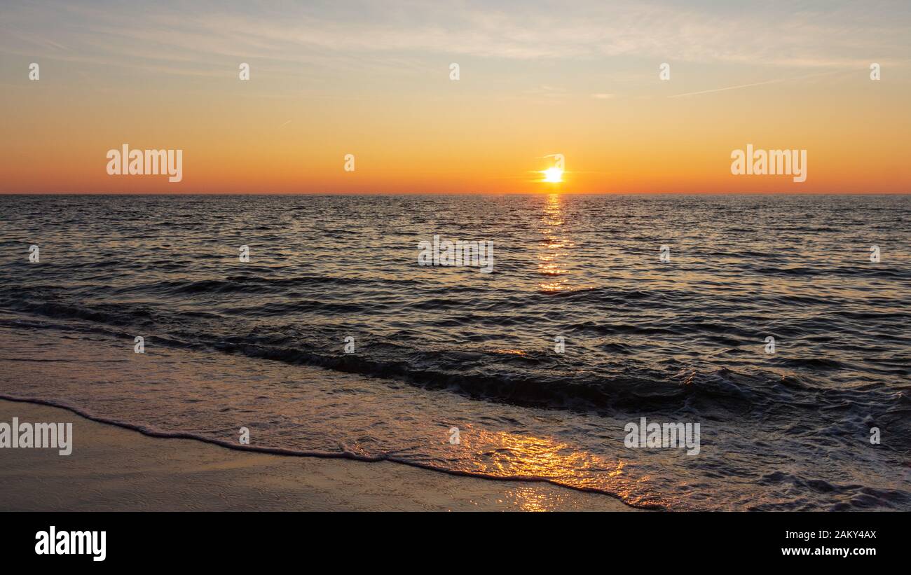 Panoramasicht auf ruhiges Meer und Sonnenuntergang an einem Strand auf der Sylt Insel in Deutschland Stockfoto