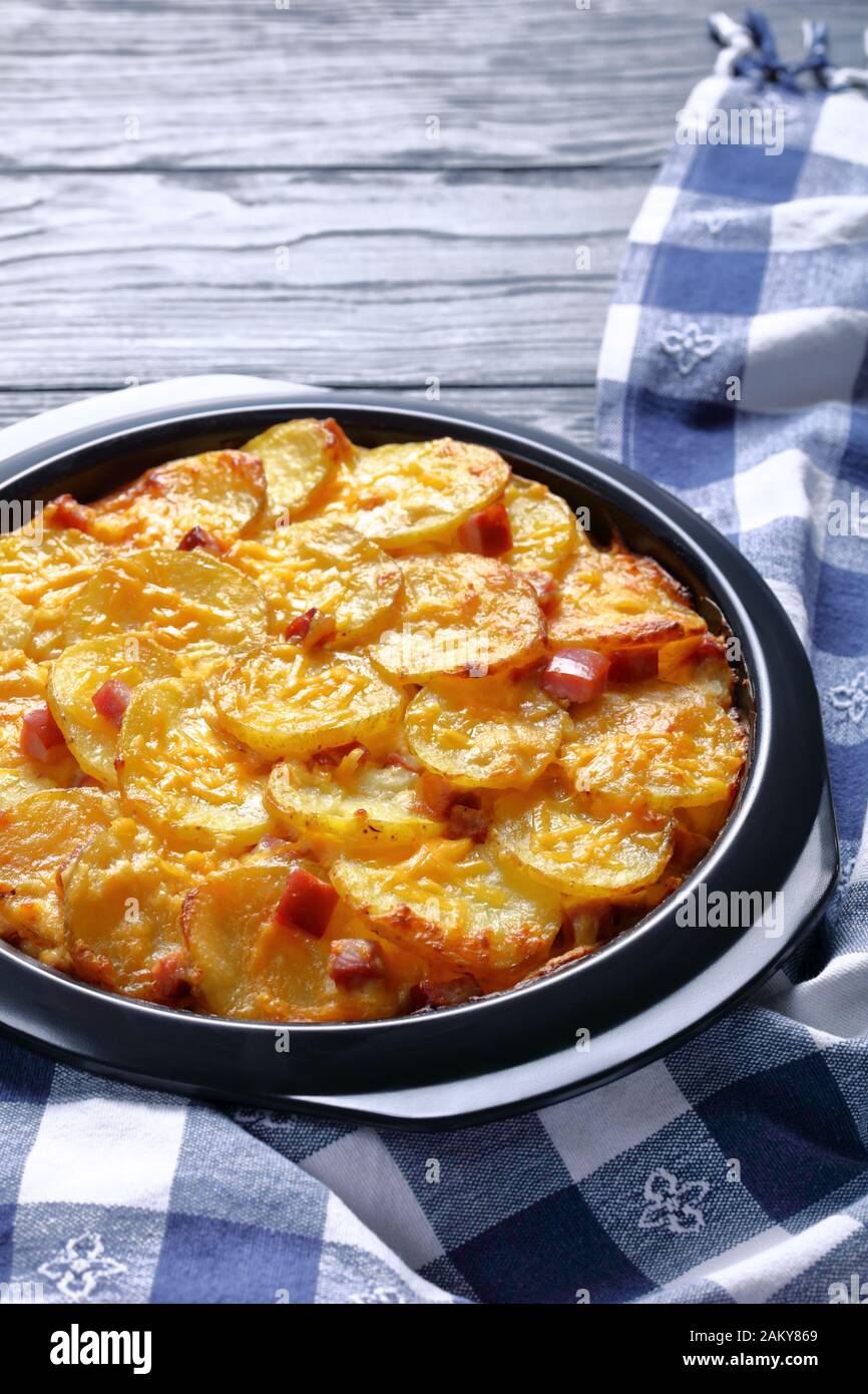 Ketzige, geschälte Kartoffeln mit Ham in einer Backform, vertikale Ansicht von oben, Nahaufnahme Stockfoto