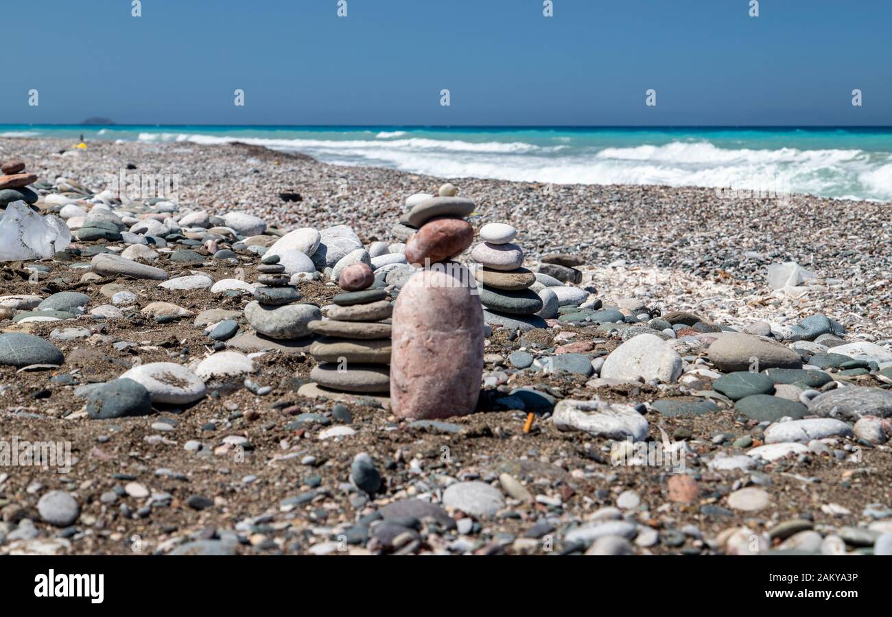 Kies-/Kieselstrand an der Südwestküste der Insel Rhodos bei Apolakkia mit Meerwasser in verschiedenen Blau- und Türkisfarben und kleinem Stein f Stockfoto