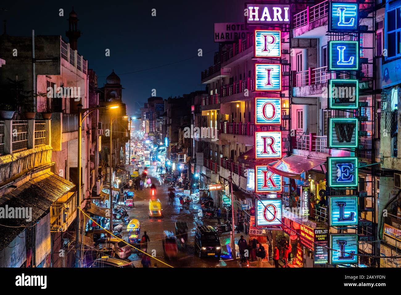 Blick auf die Hauptstraße von Main Bazaar in Paharganj mit Neon-Schildern und Verkehr in Zentral-Delhi, Indien. Stockfoto