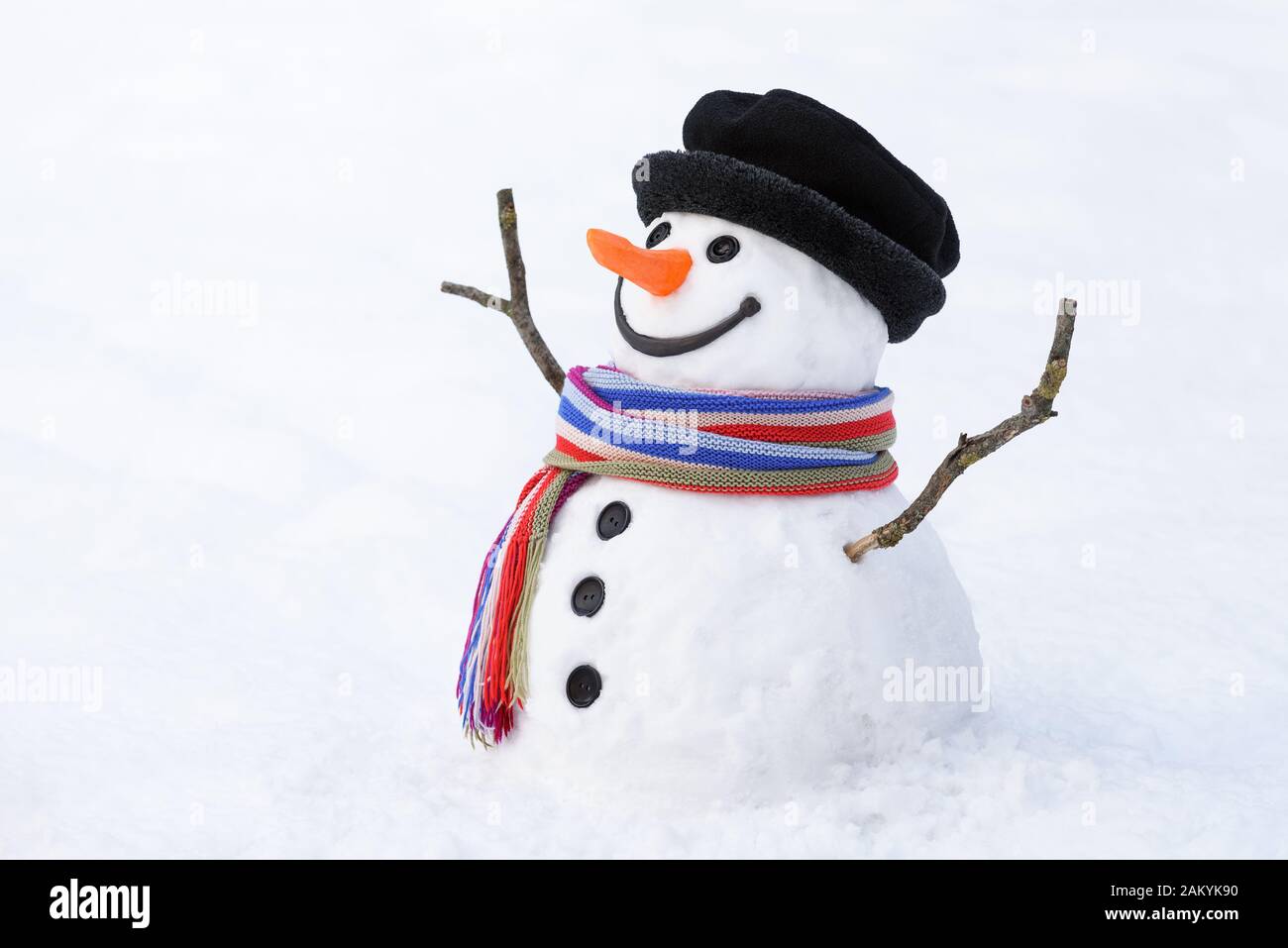 Fröhlicher Schneemann im verschneiten Hintergrund. Weihnachtskarte mit lustiger Figur. Traditioneller Winterspaß für Kinder Stockfoto