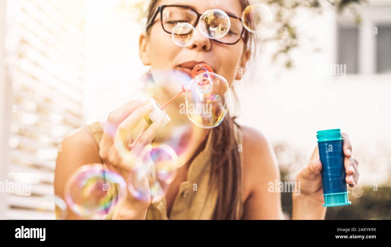 Glückliches Mädchen, das Seifenblasen im Freien blasen - Junge Frau, die draußen Spaß hat - Konzept des Spaßes, der Menschen und der Unterhaltung Stockfoto