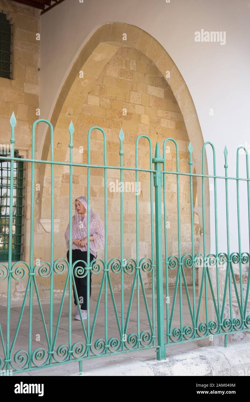 Kaukasische Frau mit Kopf, hinter Eisen Zaun, an muslimische Moschee Stockfoto