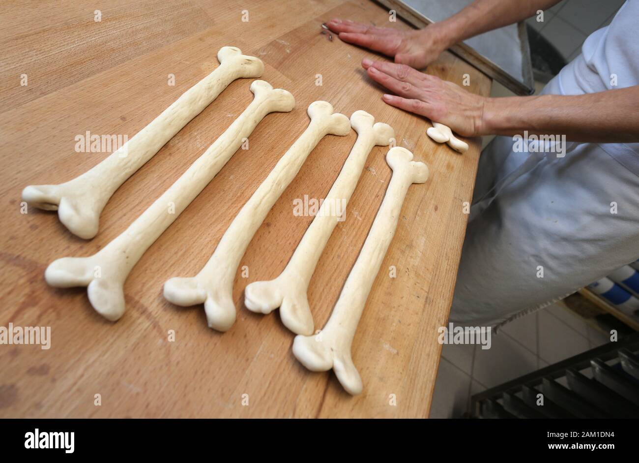 Irsee, Deutschland. 08 Jan, 2020. Gudrun Koneberg, Bäckermeister, Formulare laugen Gebäck in der Form der Knochen, die in der Bäckerei ihrer Bäckerei. Die Bäckerei ist in der Nähe von dem Ort, wo die Gebeine der Primas Udo, die etwa 11,6 Millionen Jahre alt sind, gefunden wurden. (Dpa: "Nachrichten von den Great Ape Udo - Die Primaten sind jetzt verfügbar als Brezeln') Credit: Karl-Josef Hildenbrand/dpa/Alamy leben Nachrichten Stockfoto