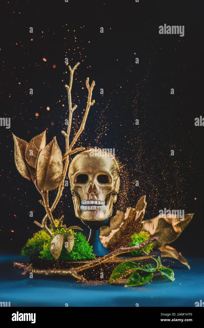 Goldene Totenkopfplastik mit Moos und Glitter, Memento mori Konzept Stockfoto