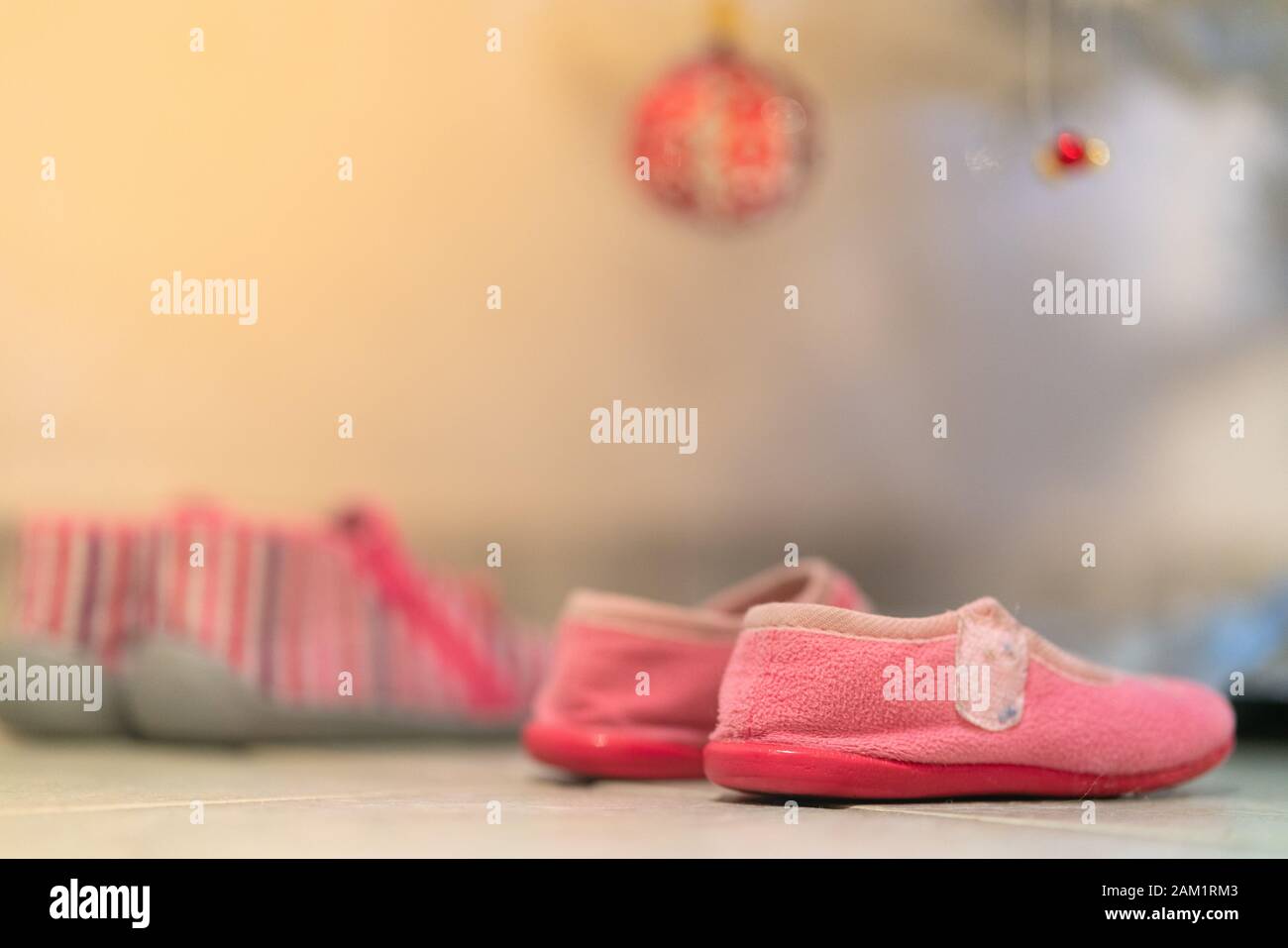 Kleine Mädchen Schuhe unter dem Weihnachtsbaum, um Geschenke zu erhalten: Französisches Konzept der Traditionen der Weihnachtstage Stockfoto