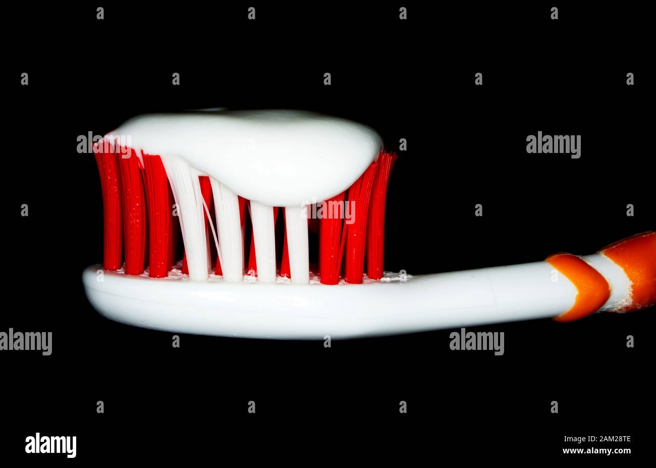 Zahnbürste und weiße Zahnpasta auf schwarzem Hintergrund. Stockfoto