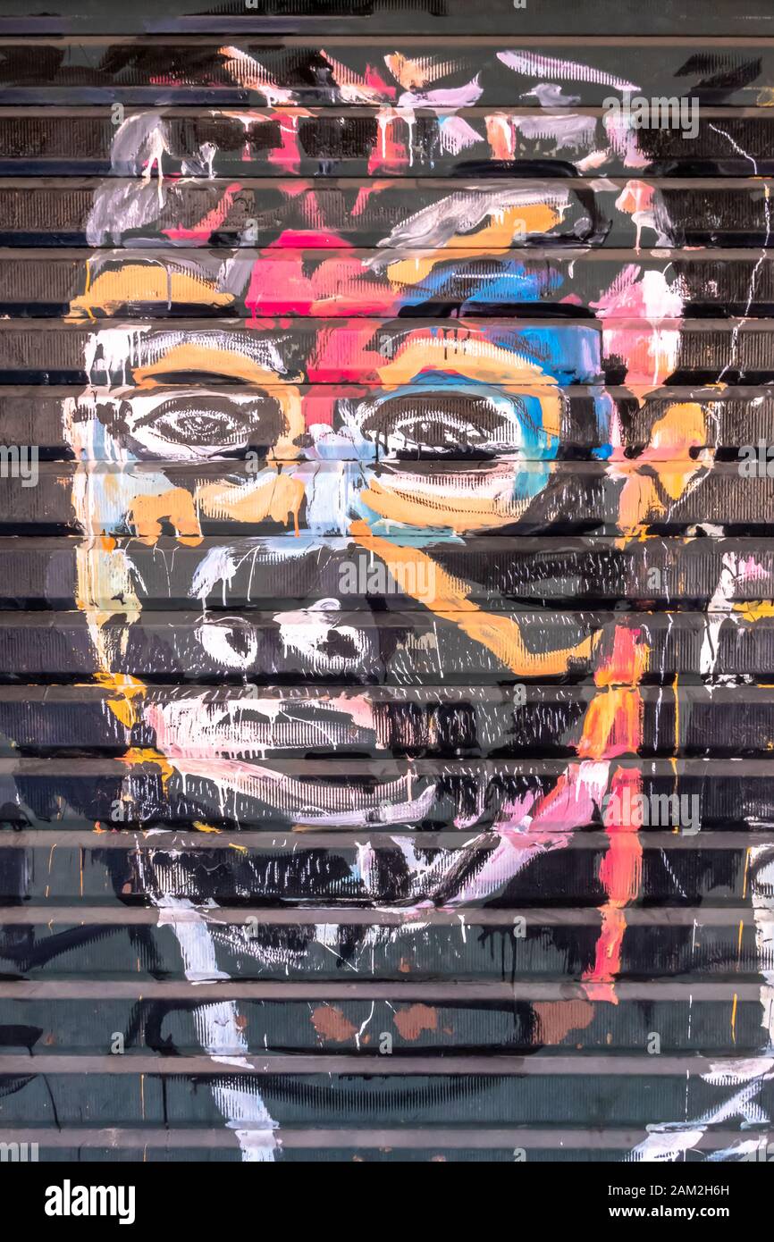 Graffiti mit dem Gesicht eines ethnischen Mannes an der alten Garagentür. Unbekannter Künstler. Bergamo, ITALIEN - 06. Mai 2019. Stockfoto