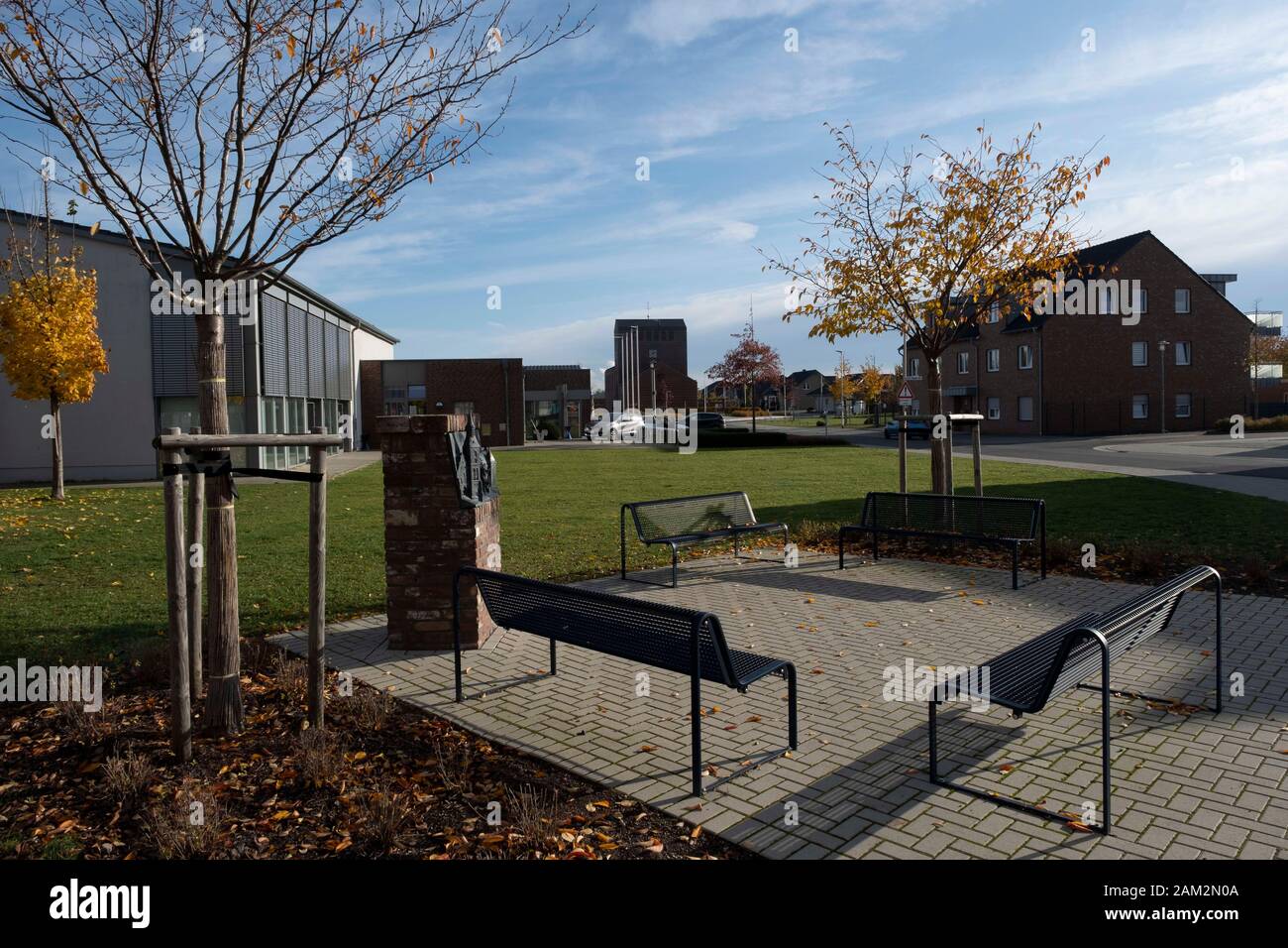 Parkbänke und Grünflächen mit öffentlicher Skulptur in Neustadt, Borschemich Neu, Deutschland Stockfoto